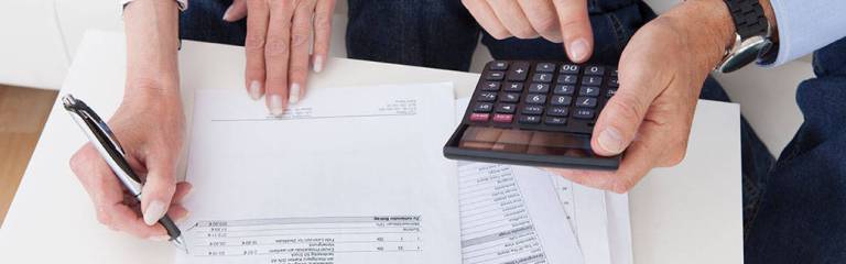 a man's hands holding a calculator, a woman's hands holding a pencil, writing on paper